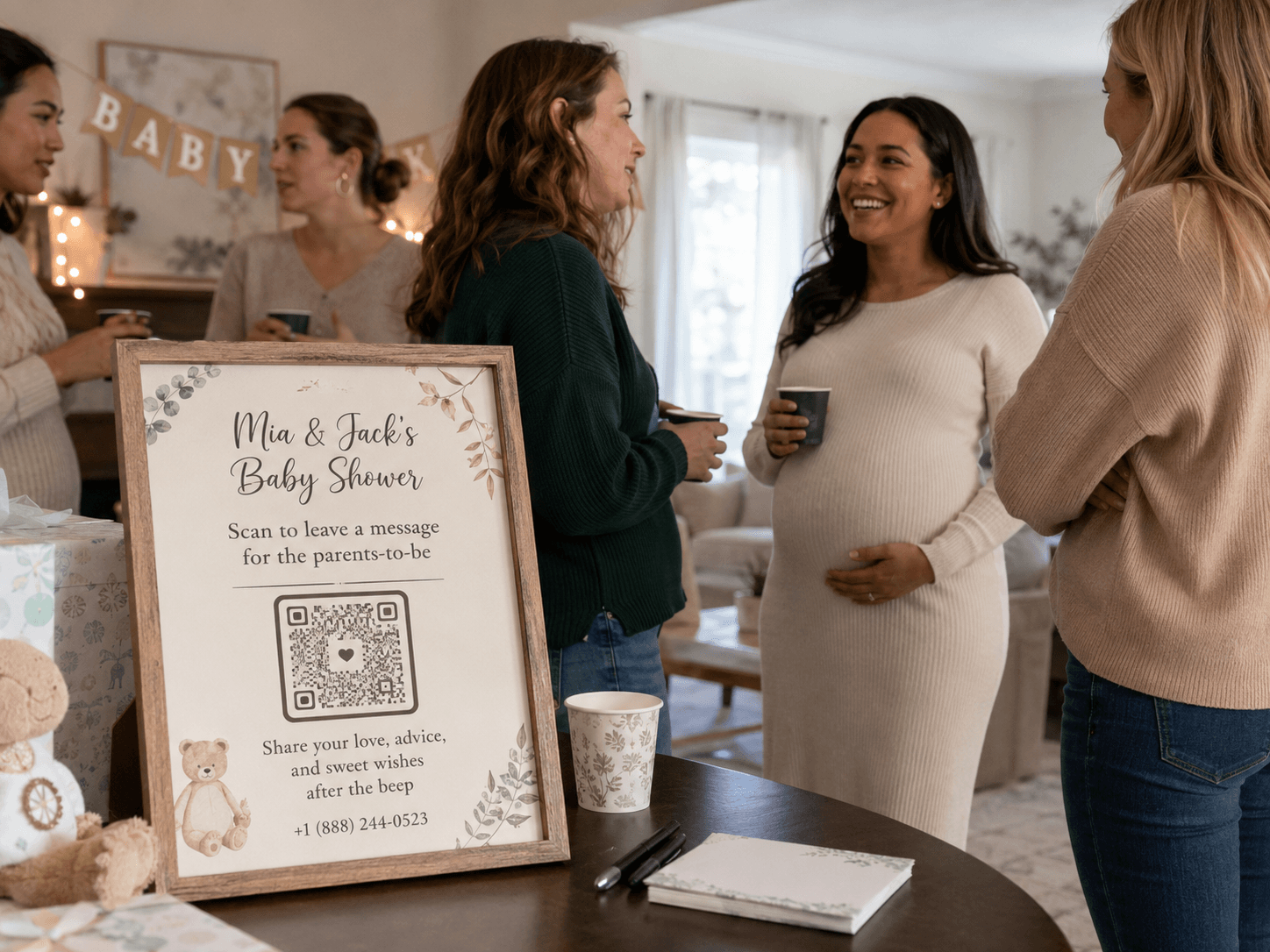 Guests at Mia and Jack’s baby shower beside a framed sign inviting them to scan and leave a voicemail for the parents-to-be